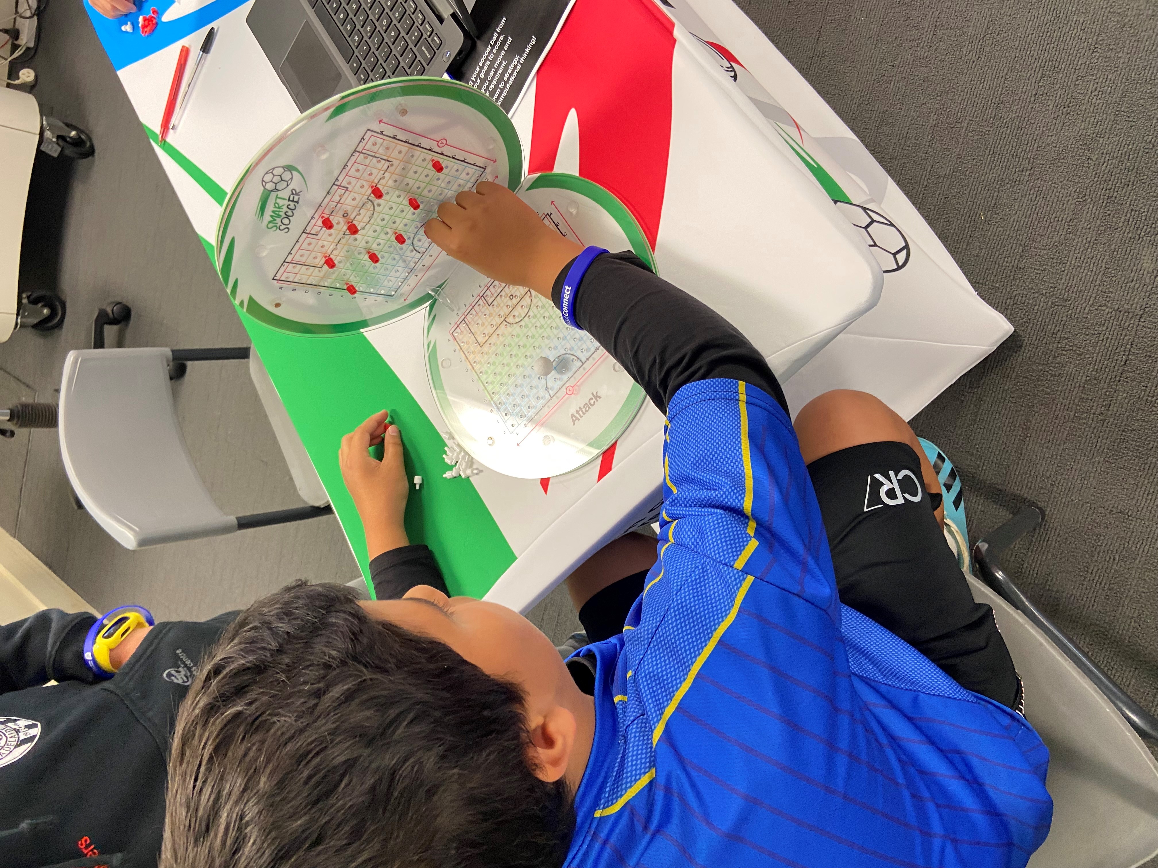 Students collaborating around the Smart Soccer board game